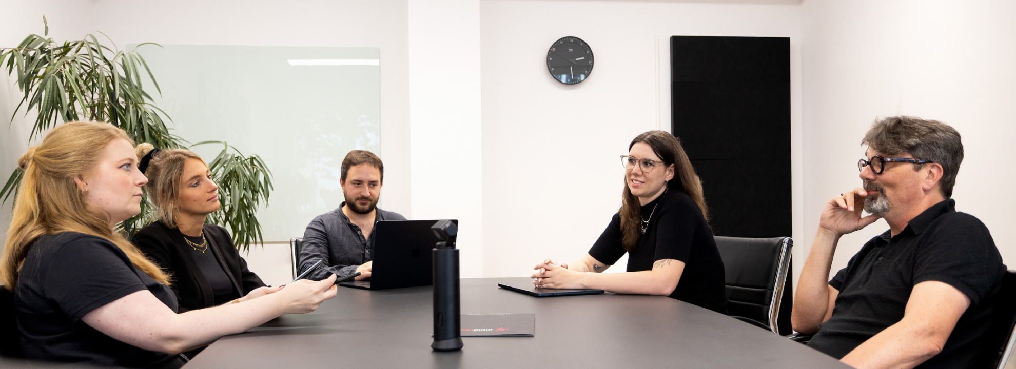 F&uuml;nf Kolleg:innen sitzen am Konferenztisch im Besprechungsraum